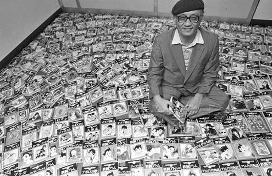 Osamu Tezuka em meio a muitos volumes de Astro Boy