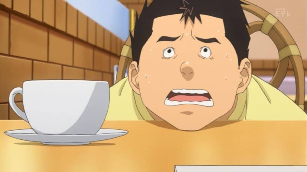Miura de Bakuman com o queixo na mesa tomando café