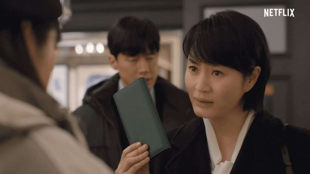 Juíza Shim Eun Seok segurando uma carteira e o juíz Cha Tae Joo ao fundo